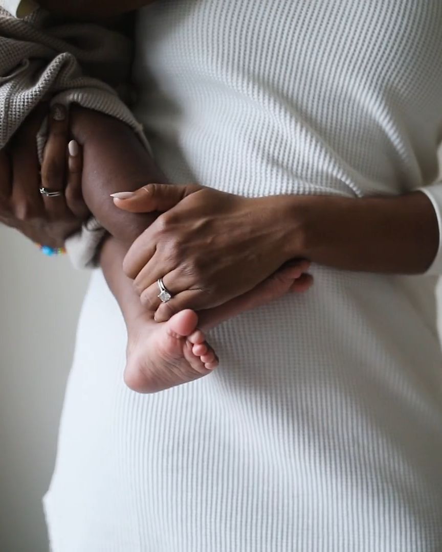 A parent's hands holding their baby